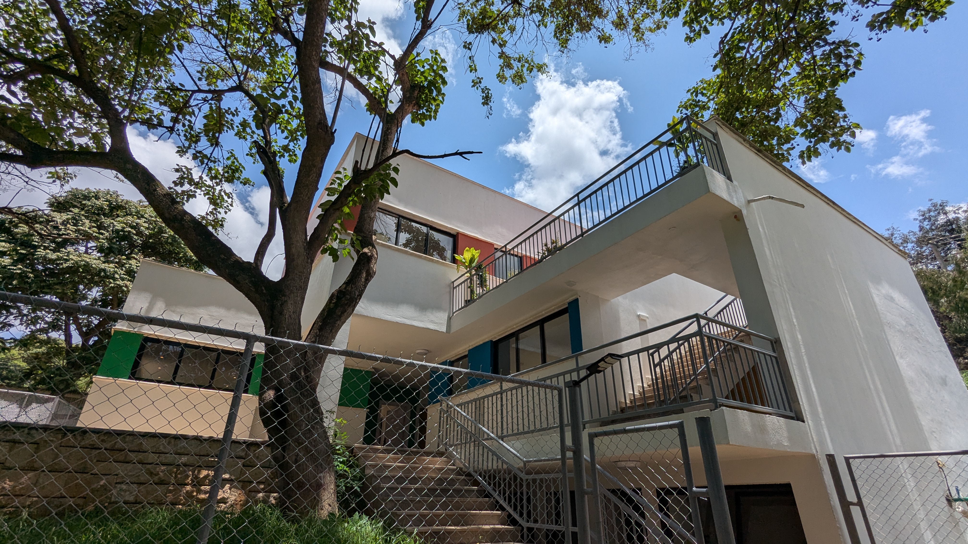 A modern Warkalab project building with terraces, trees, and bright daylight
